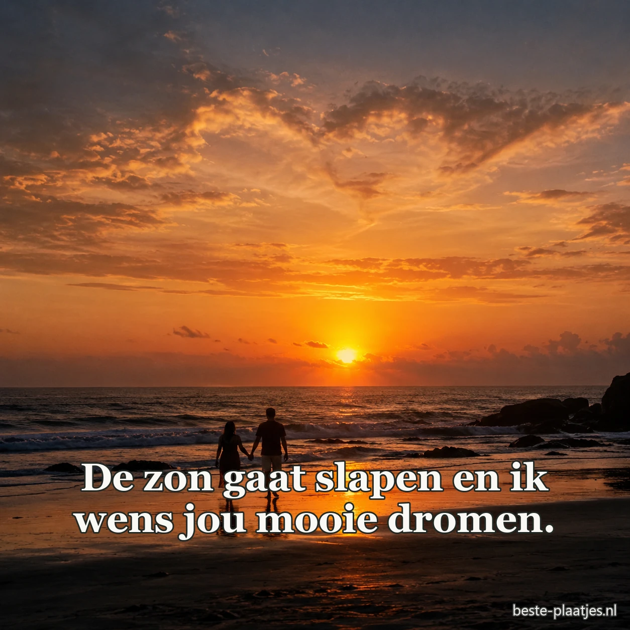 Twee mensen staan hand in hand bij zonsondergang op het strand.