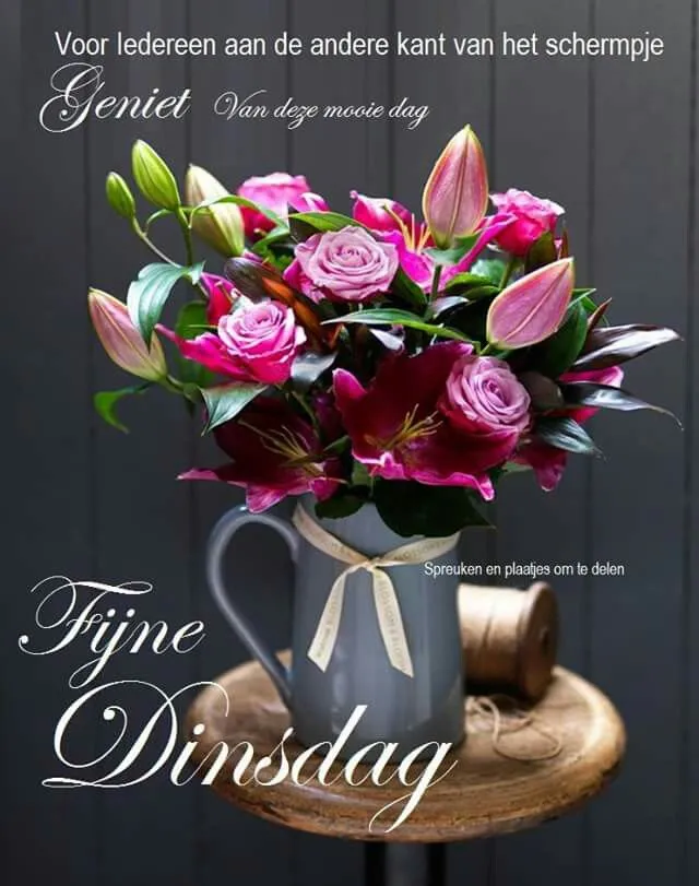 Een vaas met rozen en lelies op een houten tafel met een inspirerende tekst.